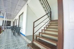 a staircase in a building with chairs and a floor at FabHotel Morjim Bliss in Morjim