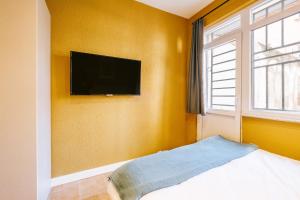 1 dormitorio con TV de pantalla plana en la pared en Modern Suite w King Bed 20 min to Hagia Sophia, en Estambul