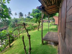 um alpendre de uma casa com um deque de madeira em GENTE D'AQUI Ngê D'ai êê em São Tomé