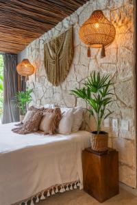 a bedroom with a bed with a plant on it at Luz de Luna Tulum Suite I in Tulum
