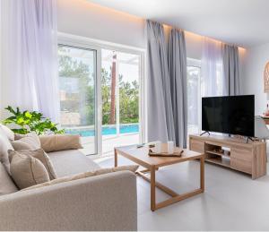 a living room with a couch and a television at serene villas in Ierápetra