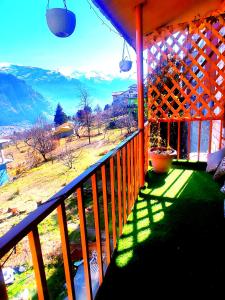 a balcony of a house with a view of the mountains at Shyam Cottage, Manali-With Kitchen in Manāli