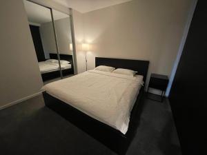 ein Schlafzimmer mit einem großen Bett und einem Spiegel in der Unterkunft New modern 1BR apt near Dickson in Canberra