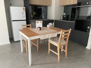 eine Küche mit einem Tisch, 2 Stühlen und einem Kühlschrank in der Unterkunft New modern 1BR apt near Dickson in Canberra