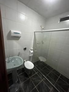 a bathroom with a toilet and a sink and a shower at Motel Las Vegas - Colatina in Collatina