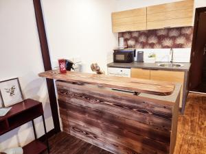 - une cuisine avec un comptoir en bois et un four micro-ondes dans l'établissement Prestigieuse Résidence : N° 1 (2 chambres spacieuses), à Bellac