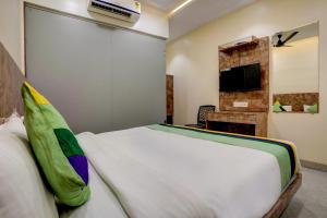 a bedroom with a white bed and a tv at Kiwi International,Hotel,Mumbai in Mumbai