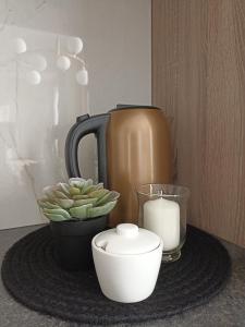 a table with a coffee pot and a candle and a plant at Apartments with a balcony and an impressive terrace on the roof of the house - PRIVATE FREE CAR PARKING in Vilnius