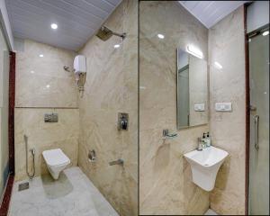 uma casa de banho com um chuveiro, um WC e um lavatório. em Kiwi International,Hotel,Mumbai em Mumbai
