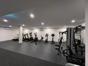 a gym with a row of treadmills and machines at New modern 1BR apt near Dickson in Canberra