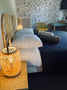 een slaapkamer met 2 bedden en een tafel met een lamp bij Chalet altitude in Pierre-Percée