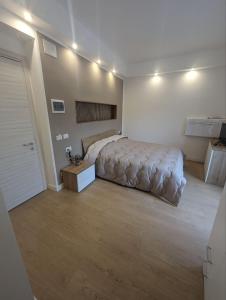 1 dormitorio con 1 cama grande y pared blanca en Affittacamere Le Vele, en Génova