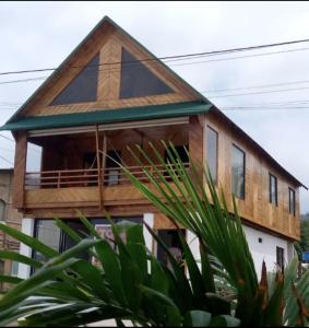 una casa con techo de gambrel y balcón en Chalet del Pacífico, en Jama