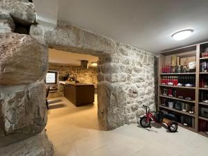 una habitación con una pared de piedra con una moto en Maison Laurel - Exquisitely Renovated Centuries Old Stone Estate With Private Pool, Near Split and Omiš, en Gata