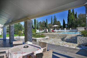 a patio with a table and chairs and a pool at Villa Iskander in Roda