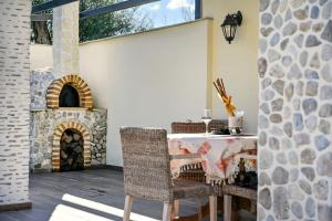 a patio with a table and a stone fireplace at Villa Iskander in Roda
