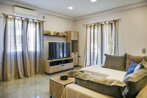 a living room with a couch and a flat screen tv at Villa Iskander in Roda