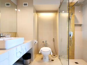 y baño con aseo, lavabo y ducha. en FuramaXclusive Pratunam Park Hotel, en Bangkok