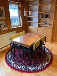 uma sala de jantar com uma mesa de madeira e cadeiras num tapete em Historische Unterkunft 2 in Lorch em Lorch