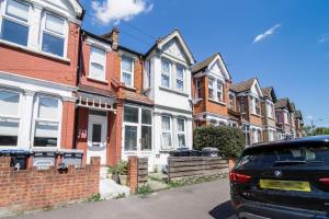 a car parked in front of a row of houses at Two Bedroom Apartment in London Harlesden in London