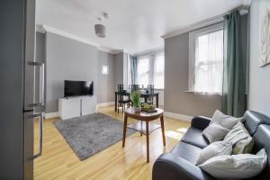 a living room with a couch and a table at Two Bedroom Apartment in London Harlesden in London