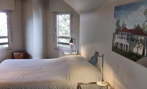 um quarto com uma cama branca e 2 janelas em La villa M Vannes, villa les pieds dans l'eau sur le port, avec grand jacuzzi em Vannes