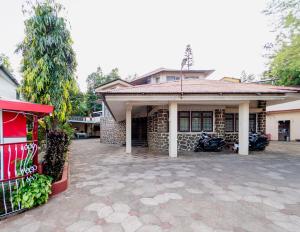 a house with a motorcycle parked in front of it at Treebo Trend Raval Resort in Panchgani