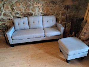 un sofá y un taburete en la sala de estar en Casa Tenada en Robledo