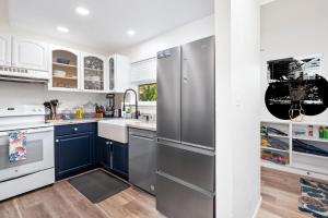 una cocina con armarios azules y electrodomésticos de acero inoxidable en Big Island Waikoloa Hills 1304 condo, en Waikoloa Village