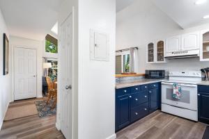 una cocina con armarios azules y electrodomésticos blancos en Big Island Waikoloa Hills 1304 condo, en Waikoloa Village