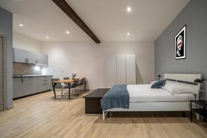 Cet appartement comprend une chambre avec un lit et une table ainsi qu'une cuisine. dans l'établissement Casa Nicola dietro l'Arena, à Vérone