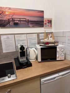 eine Küchentheke mit einer Mikrowelle und einem Telefon in der Unterkunft Safit-Mandala in Mosonmagyaróvár