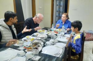 a group of people sitting around a table eating food at Vedic Life Homestay & Wellness Centre in Jaipur
