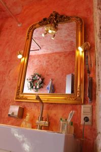 a mirror on a wall above a bathroom sink at Bavaria Bad Birnbach in Bad Birnbach