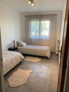- une chambre avec 2 lits et une fenêtre dans l'établissement Charmant T3 en résidence privée, à Marseille