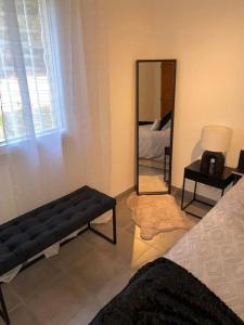 - un salon avec un canapé noir et un miroir dans l'établissement Charmant T3 en résidence privée, à Marseille