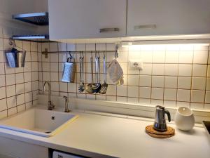 cocina con fregadero y pared de azulejos blancos en Ravenna48, en Milán
