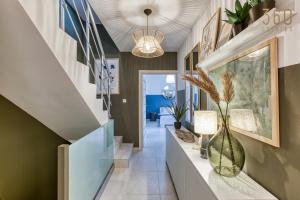 un couloir d'une maison avec des vases et un escalier dans l'établissement LUX Duplex Penthouse w/ Expansive Rooftop Terrace by 360 Estates, à San Ġwann