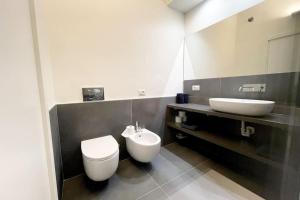 bagno con servizi igienici bianchi e lavandino di Charlotte House City Center a Milano