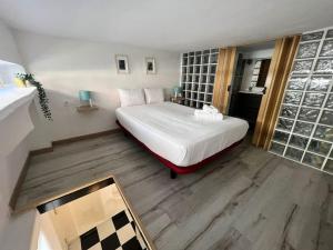 a bedroom with a large white bed and wooden floors at Nice apartment at street level 20 min from SOL-Piern in Madrid