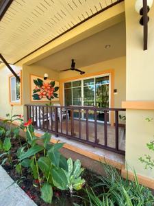 a house with a porch with a fence at Sweet Mango Khaolak in Khao Lak