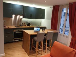 a kitchen with a table with a laptop on it at Appartement Cosy Plein Centre Ville in Meulan