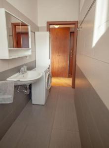 a small bathroom with a sink and a refrigerator at La Settima Arte - Milano Sarca in Milan