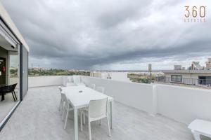 - Balcón blanco con mesa blanca y sillas en LUX Duplex Penthouse w/ Expansive Rooftop Terrace by 360 Estates, en San Ġwann 38 fotos más