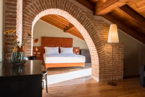 a bedroom with a bed and a brick wall at Pavillon Suite in Peschiera del Garda