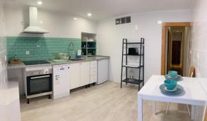 a kitchen with white cabinets and a table with blue bowls on it at Heart of Lisbon Apartment in Lisbon