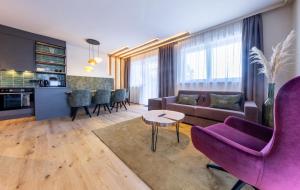 sala de estar con sofá púrpura y mesa en Höflehner Premium Gumpen Lodge en Haus im Ennstal