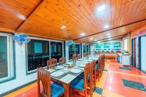 a dining room with a long table and chairs at Treebo Trend Raval Resort in Panchgani