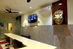 a kitchen with a counter and a tv on the wall at Hotel MoonLite Residency - Near Aksa Beach Marve Malad West in Mumbai