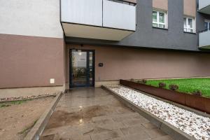 a building with a door and a walkway in front at 12th Floor Wola Modern Apartment in Warsaw